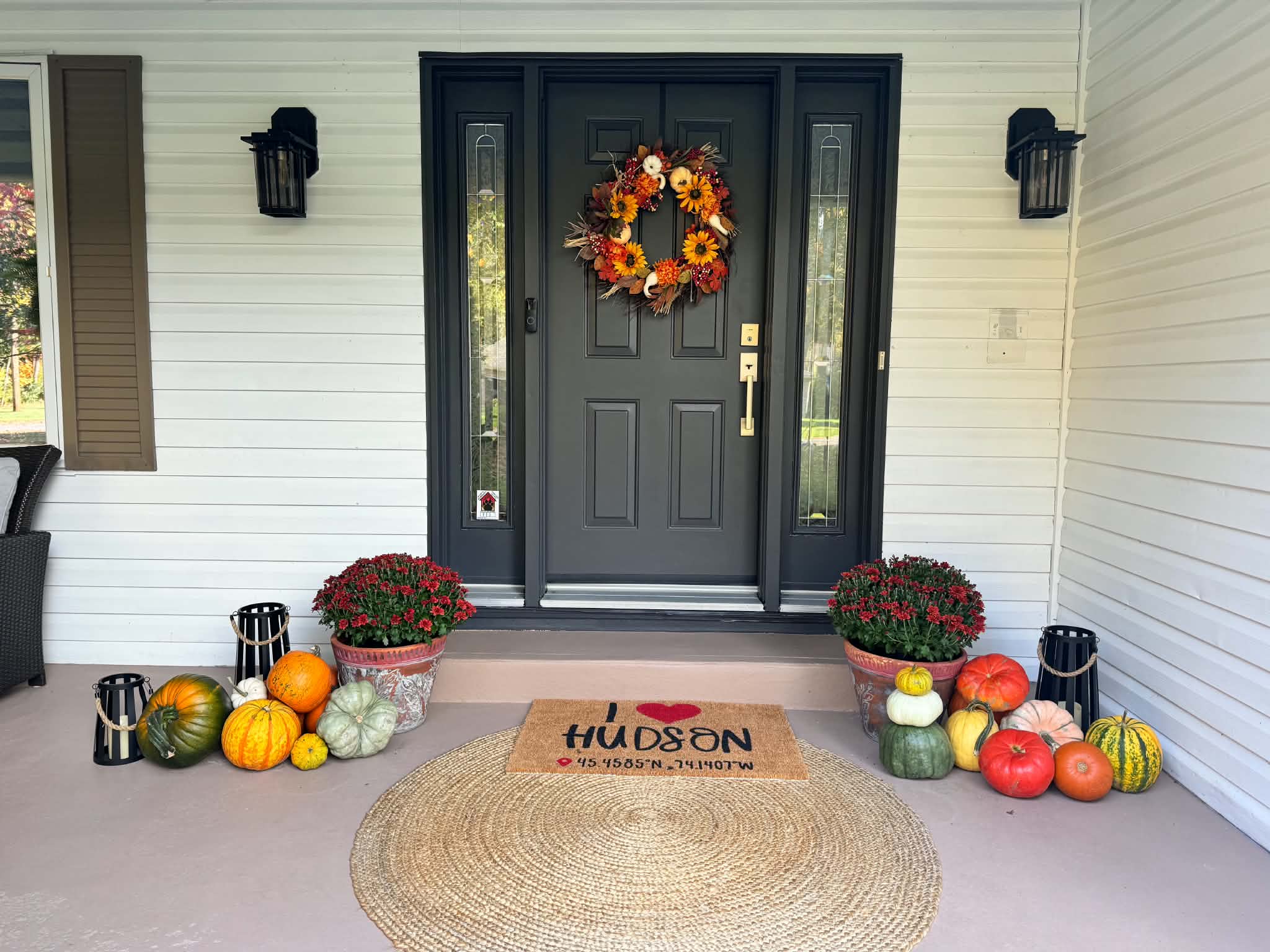 Perron couvert exécutif avec couronne d'automne, lanternes noires et citrouilles patrimoniales à Vaudreuil-Dorion